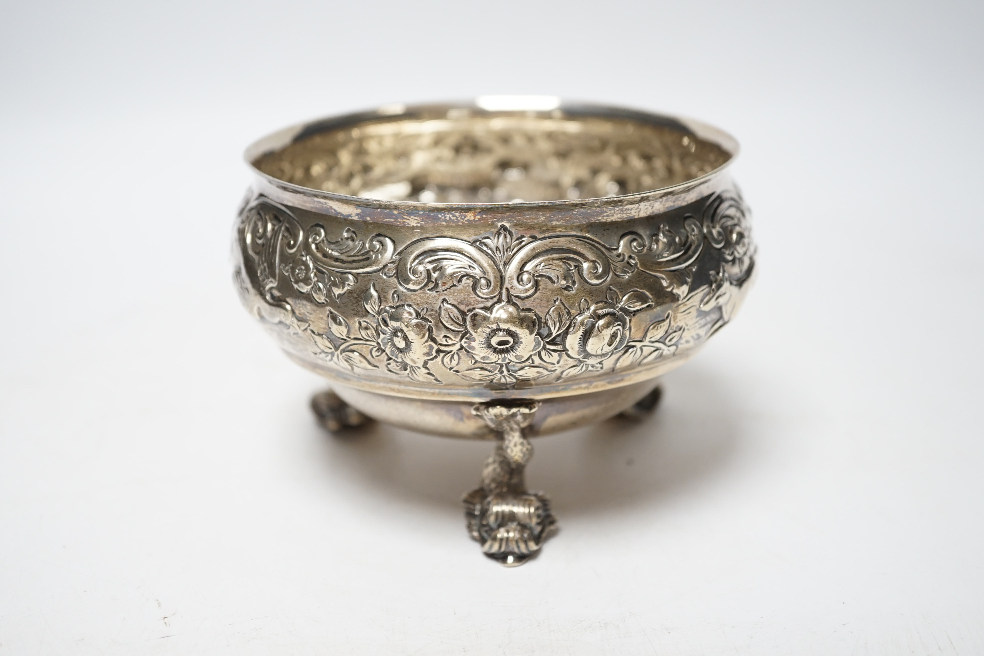 An Edwardian embossed silver bowl, on three dolphin supports, Wakely & Wheeler, London, 1905, diameter 11.6cm, 11.4oz.